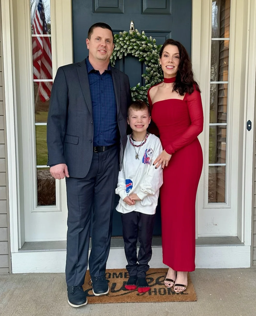 Jim Barrett with his wife and their son at their front door.